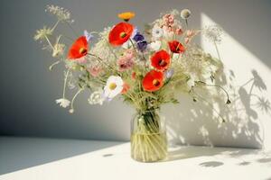 ai generiert Strauß von Wildblumen im ein klein Glas Vase auf das Weiß Tisch. Mohn, Kamille, Kornblumen, Grün Gras. Sommer- Foto. Kontrast Schatten auf das Weiß Mauer. Land Stil. foto