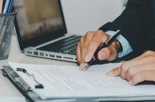 Geschäftsmann mit Computer-Laptop und Stift-Papierkram dokumentieren einen Schreibtisch. Unternehmensfinanzierung, Steuern und Investitionskonzepte. foto