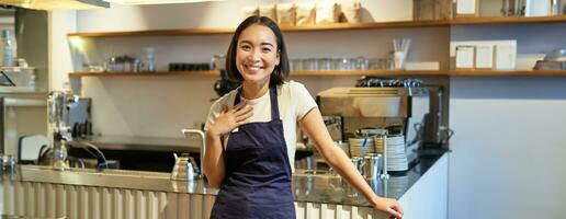 Porträt von lächelnd asiatisch Unternehmer, unabhängig Kaffee Geschäft Eigentümer, tragen Schürze, Arbeiten im Cafe, tragen Schürze foto