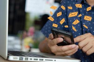 Nahaufnahme Mann mit einem Handy eine Symbol-E-Mail-Nachricht. Marketingunternehmen, die Informationen an Kunden senden oder Online-Transaktionen hacken. Business-Konzept-Technologie.