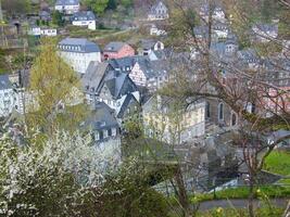 ein Aussicht von ein Stadt, Dorf mit ein Uhr Turm und ein wenige Häuser foto