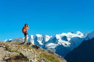Mädchen fotografiert hohe Berge der Alpen foto