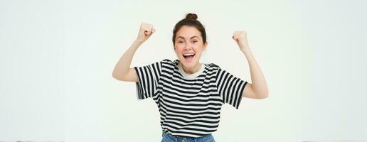 Porträt von glücklich jung Sport Mädchen, Ventilator Verwurzelung zum Team, feiern Sieg, erziehen Hände hoch, Singen, triumphierend, Stehen Über Weiß Hintergrund foto