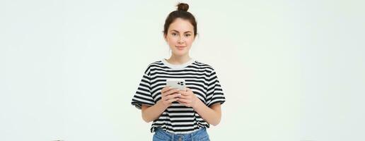 Technologie und Lebensstil. jung Frau Stehen Über Weiß Hintergrund mit Smartphone foto