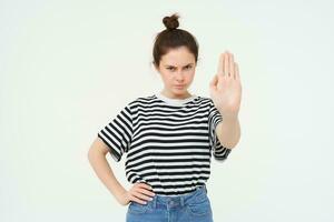 Bild von Frau stirnrunzelnd, zeigen einer Palme, halt Geste, missbilligen und ablehnen etwas, macht verbieten Geste, Stehen Über Weiß Hintergrund foto
