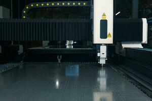 industriell Laser- Schneiden Maschine während Metall Blatt wird bearbeitet foto