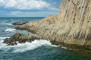 natürlich Landschaft mit ein schier Cliff gefaltet säulenförmig Basalt auf das Strand foto