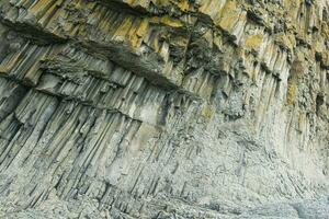 Fuß von ein Küsten Cliff zusammengesetzt von säulenförmig Basalt, auf das Insel von Kunaschir foto