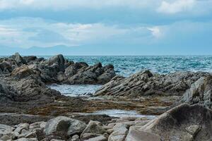 Scharf gezackt Basalt Felsen auf das Meer Küste foto