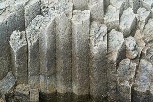 natürlich Hintergrund, das Oberfläche von ein vulkanisch Küsten Felsen von Basalt Prismen foto