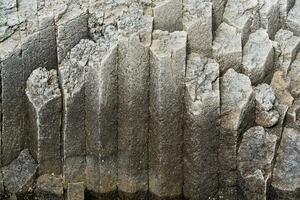 natürlich Hintergrund, das Oberfläche von ein vulkanisch Küsten Felsen von Basalt Prismen foto