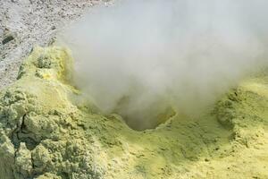 Rauchen Solfatara unter Schwefel Einlagen auf ein Fumarole Feld auf das Steigung von ein Vulkan foto