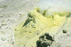 Gelb Kegel von kristallisiert Schwefel um ein Rauchen Solfatara auf das Steigung von ein Vulkan foto