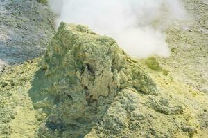 kristallisiert Schwefel um ein Rauchen Solfatara auf das Steigung von ein Vulkan foto