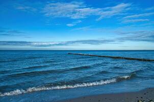 auf das Küste von das baltisch Meer. Wellen rollen auf zu das sandig Strand. Natur Foto