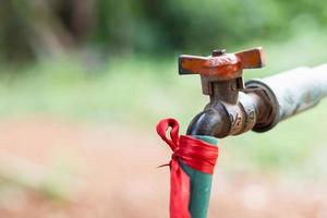 Schläuche, die mit einem alten Anschluss an der Rückseite des Hauses an den Wasserhahn angeschlossen werden foto