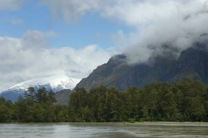 Schnee bedeckt Spitzen im Wolken, Caleta Tortel, aysen Region, Patagonien, Chile foto