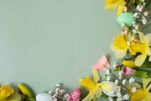 Frühling Blumen und Ostern Eier Rand auf Grün Hintergrund mit Kopieren Raum. Ostern Gruß Karte Vorlage foto
