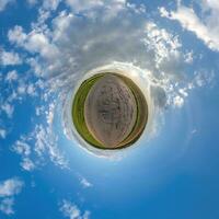 Grün winzig Planet im Abend Blau Himmel mit schön Wolken. Transformation von kugelförmig Panorama 360 Grad. kugelförmig abstrakt Antenne Sicht. Krümmung von Raum. foto