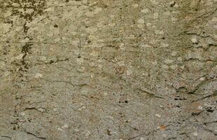 Nahaufnahme der rauen Steinstruktur einer großen Felsoberfläche für natürliche Hintergrundkonzepte. Closeup schmutzige Naturstein Hintergrundtextur foto