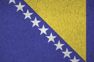 flagge von bosnien und herzegowina in hellen farben auf alter reliefputzwand dargestellt. strukturierte Fahne auf rauem Hintergrund foto
