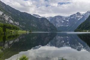 Hallstätter Meer mit Spiegelungen der Alpen und des Himmels im ruhigen Wasser. foto