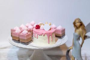 der rosa kuchen steht auf dem weißen tisch foto