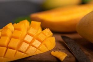 Nahaufnahme von geschnittenen Mangostücken vor einem dunklen Hintergrund foto