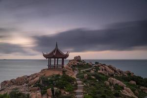 morgens scheint die sonne auf die felsen und wellen am strand foto