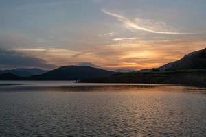 der abendsee spiegelte die berge und den himmel auf beiden seiten foto