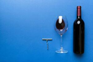 eben legen Komposition mit Korkenzieher, Flasche von Wein und elegant Glas auf farbig Tisch. eben legen, oben Aussicht mit Kopieren Raum foto