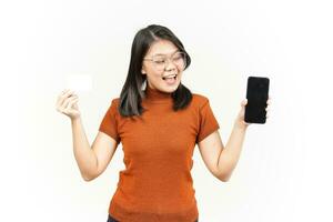 halten leer Bank Karte und Smartphone mit leer Bildschirm von schön asiatisch Frau isoliert auf Weiß foto