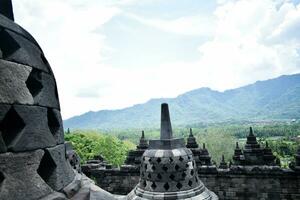 das Schönheit von Borobudur Tempel, mit ein Hintergrund von Grün Wälder und Blau Himmel foto