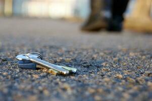 ein Mann verlieren Schlüssel auf das Straße. foto