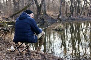 Angeln Stange im das Hände von ein Fischer auf das See. foto