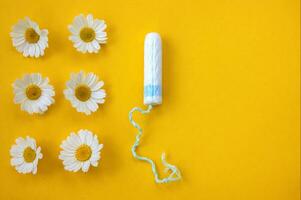 hygienisch medizinisch weiblich Tampon mit Kamille um auf ein Gelb Hintergrund. foto