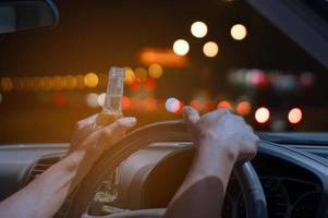 Nicht trinken und fahren Konzept, betrunken und Autofahren mit einer Flasche Alkohol foto