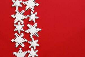Weiß geschnitzt Schneeflocken von Mastix auf rot Hintergrund. foto
