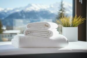 ai generiert ein Stapel von Weiß Handtücher auf ein Bett im ein Hotel Zimmer, gegen das Hintergrund von ein Panorama- Fenster mit Blick auf Grün alpin Wiesen foto