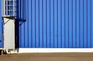 Blau Hintergrund Metall Mauer Abstellgleis, Verkleidung mit Treppe zu das Dach. foto