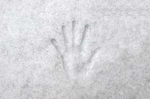 Handabdruck mit Finger im Weiß Schnee, Hintergrund, Textur. foto