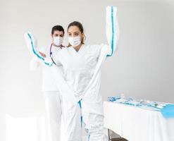 Arzt, der während der Coronavirus-Pandemie Schutzkleidung anzieht foto