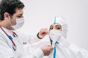 Sanitäter, der während der Covid-19-Epidemie Schutzkleidung anzieht foto