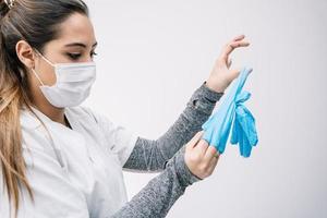 Arzt zieht Handschuhe nach der Arbeit im Krankenhaus aus foto