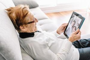 Inhalt gealterte Frau, die über Video-Chat auf Tablet spricht foto