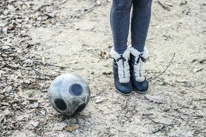 Mädchen Fuß in der Nähe von das Fußball Ball. Straße Spiele mit das Ball. foto