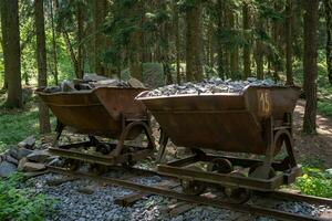 Bergbauwagen mit Steinen. alter und verlassener Bergbauwagen im Wald. foto