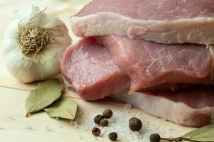 frisch Schweinefleisch mit Zutaten zum Kochen auf hölzern Tafel foto