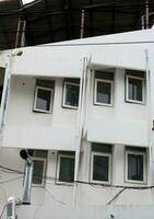 Vorderseite von alt Weiß Gebäude, geschlossen Fenster mit Farbton, geometrisch gestalten Niveau Design, Thailand. foto
