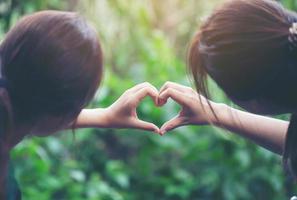 Frauen machen mit ihren Händen Herzformen foto